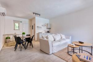 a living room with a white couch and a table at Saronis Suites in Saronida