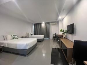 Habitación de hotel con 2 camas y TV en We Grand Ever 9, en Nakhon Ratchasima