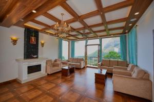 a large living room with a fireplace and a chandelier at The Planet Munnar in Suryanelli