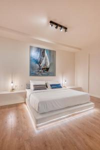 a large white bedroom with a large white bed at Saronis Suites in Saronida