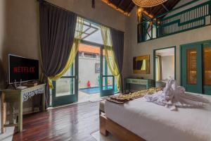 1 dormitorio con cama y ventana grande en The Reward Villas Kerobokan en Seminyak