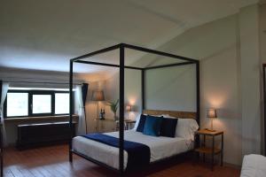 a bedroom with a canopy bed with blue pillows at Casa M Vineyard in Chianciano Terme