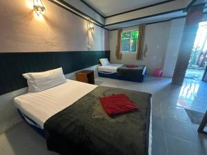 Una habitación de hotel con dos camas y una ventana. en PhiPhi Film House, en Islas Phi Phi