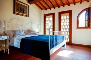 a bedroom with a bed with a blue blanket at Tenuta I Mandorli in Peccioli
