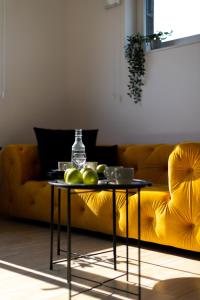 a table with fruit on it in front of a yellow couch at Starter 24 Wrocław in Wrocław