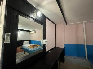 Una pequeña habitación con una cama y un espejo. en PhiPhi Film House, en Islas Phi Phi 9 fotos más