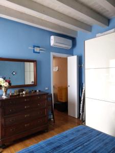 a bedroom with a bed and a dresser and a mirror at La casa di Pia in Càbras