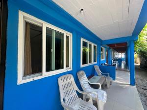 una casa azul con 2 sillas y una mesa en PhiPhi Film House, en Islas Phi Phi