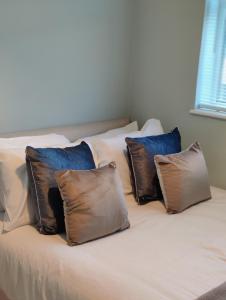 Una cama con tres almohadas encima. en Beachgrove House, en Bristol