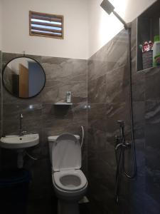 uma casa de banho com um WC, um lavatório e um espelho. em Denai Senja em Kuala Selangor