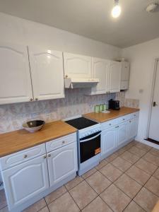 a kitchen with white cabinets and a stove top oven at Beachgrove House in Bristol