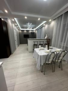 een eetkamer met een witte tafel en stoelen bij 2х комнатная квартира в ЖК Тавангар с евроремонтом in Aqtöbe