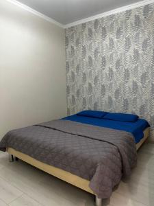 a bedroom with a bed with a blue blanket at 2х комнатная квартира в ЖК Тавангар с евроремонтом in Aktobe