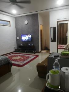 uma sala de estar com um sofá e uma televisão em Denai Senja em Kuala Selangor