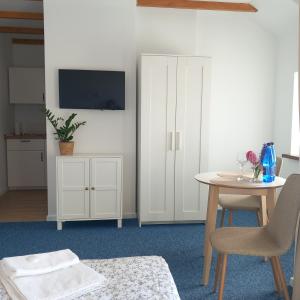 a living room with a table and a white cabinet at Na Fali in Jastarnia