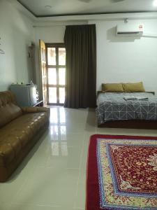uma sala de estar com um sofá e uma cama em Denai Senja em Kuala Selangor