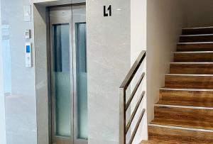 a glass door in a building with a stairway at Lea Robert Hotel Angeles Pampanga by RedDoorz in Angeles