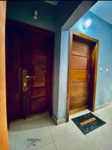 a hallway with a wooden door and a tile floor at RESIDENCE LUXALYS in Yaoundé