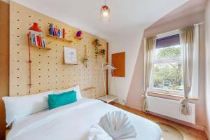 una camera da letto con un grande letto bianco e una finestra di Enchanting 3 bedroom house with garden in Leyton a Londra