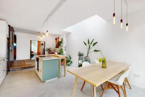 Enchanting 3 bedroom house with garden in Leyton في لندن: مطبخ وغرفة طعام مع طاولة خشبية