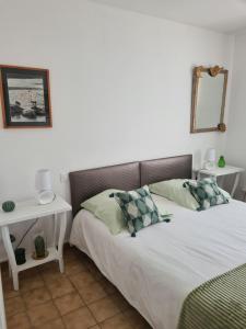 a bedroom with a bed and a white table at Villa Hélios in Canet-en-Roussillon