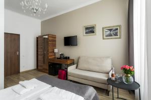 - une chambre avec un lit, une chaise et une table dans l'établissement G12 Aparthotel, à Cracovie