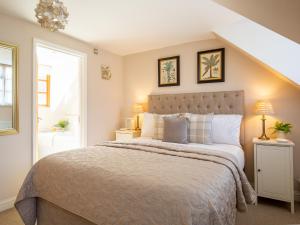 Un dormitorio con una cama grande y una ventana en Teagles Cottage, en Stow on the Wold