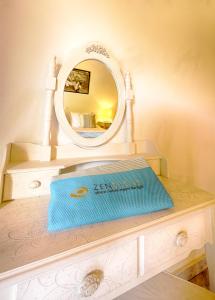 a dressing table with a mirror and a blue item on it at Zen Stone House in Agios Georgios Pagon