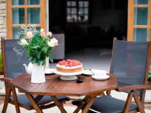 una mesa con un pastel y un jarrón de flores en Teagles Cottage, en Stow on the Wold