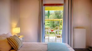 a bedroom with a bed and a view of a patio at Zen Stone House in Agios Georgios Pagon