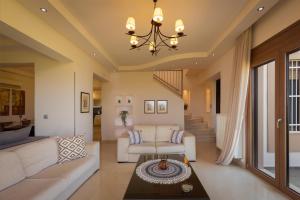 a living room with a couch and a chandelier at Majestic View Villa in Kolymbia