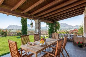 Une table et des chaises en bois sont disponibles sur la terrasse. dans l'établissement Majestic View Villa, à Kolimbia