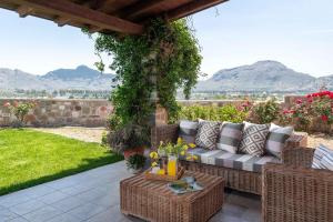 a patio with a couch and a pergola with mountains at Majestic View Villa in Kolimbia
