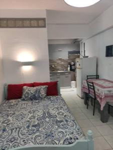 een slaapkamer met een bed en een tafel en een keuken bij Όμορφο διαμέρισμα με μπαλκόνι στη Σαρωνίδα in Saronida