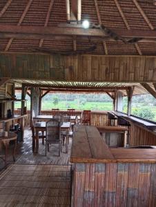 - Zona de comedor con mesas y sillas en un edificio en Amed Stop Inn Homestay, Rooftop Restaurant and Bar en Amed