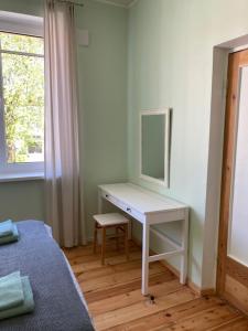 a bedroom with a desk with a mirror and a bed at Lahe koht in Haapsalu