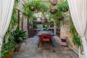 un patio con mesa, sillas y plantas en Le Voyage d'Ulysse, en Marsillargues
