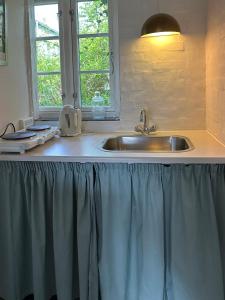 a kitchen counter with a sink and a window at Anne Just's Havehotel in Blokhus +22 photos