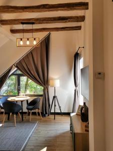 een woonkamer met een tafel en stoelen en een raam bij Casa Larisa Antonia Apartment in Sinaia