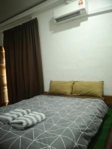 ein Bett mit einer Decke darauf in einem Schlafzimmer in der Unterkunft Denai Senja in Kuala Selangor