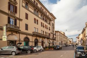 una calle de la ciudad con coches estacionados frente a los edificios en Liberty Guest House, en Lucca