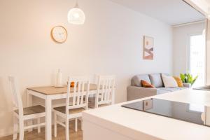 cocina blanca y sala de estar con mesa y sillas. en Snowflake Suites VI, en Rovaniemi
