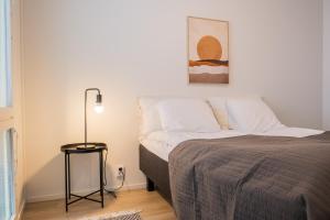 um quarto com uma cama e um candeeiro em Snowflake Suites VI em Rovaniemi