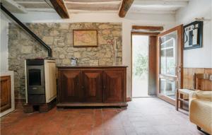 a living room with a stone wall and a tv at 1 Bedroom Beautiful Apartment In Castelfranco Piandisc in Castelfranco di Sopra