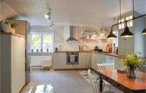eine große Küche mit einem Holztisch und Stühlen in der Unterkunft 3 Bedroom Lovely Home In Dalar in Dalarö