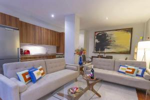 sala de estar con 2 sofás y cocina en Chueca Gran Via Recoletos Libertad 24 4 en Madrid