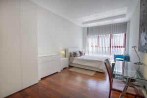 a white bedroom with a bed and a window at Chueca Gran Via Recoletos Libertad 24 4 in Madrid