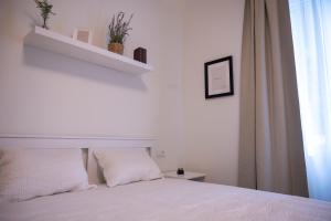 a white bedroom with a bed and a window at Pop luxury apartments in Belgrade