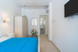 1 dormitorio con 1 cama azul y TV en La fuga blu di Marzamemi, en Marzamemi