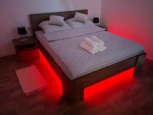 a bedroom with a bed with red lights on it at Apartamenty Aleksandra in Biały Dunajec